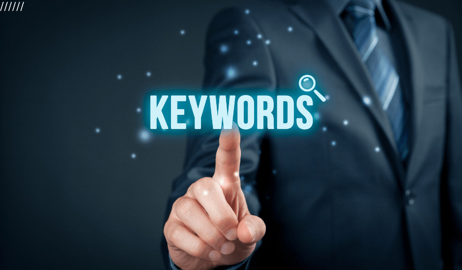 ﻿Businessman pointing at the word keywords, representing advanced keyword research strategies for SEO